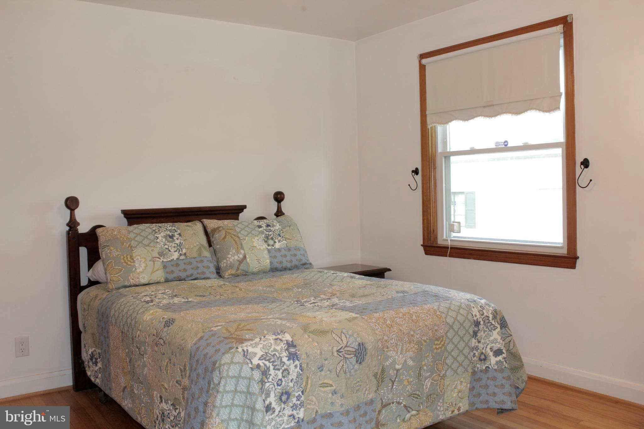 112 17th Avenue Baltimore, MD 21225 - Photo 21 of 40 a bedroom with a bed and a window