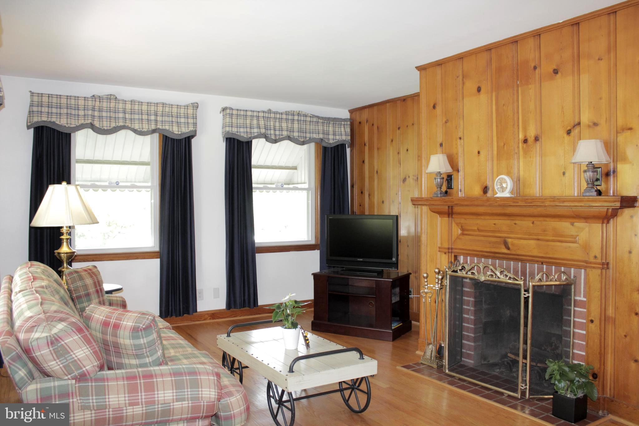 112 17th Avenue Baltimore, MD 21225 - Photo 7 of 40 a living room with furniture a fireplace and a large window