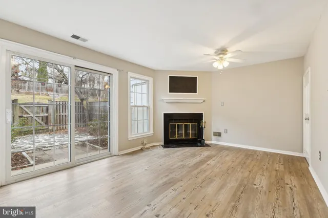 a view of an empty room with a fireplace and a window