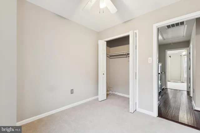 a view of a hallway with closet and wooden floor