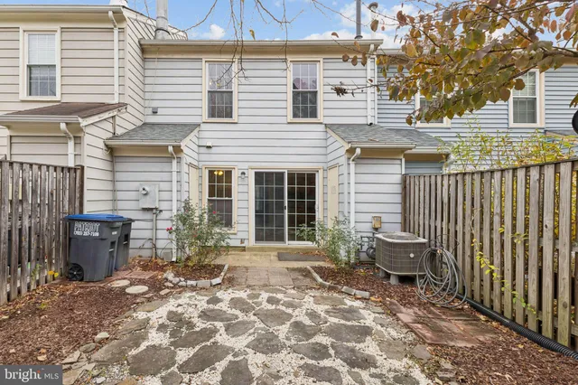 a view of a patio with a table and chairs and wooden fence