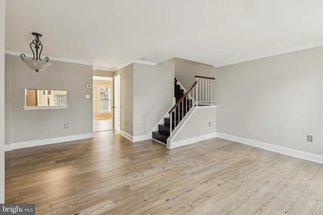 a view of a livingroom with wooden floor and stairs
