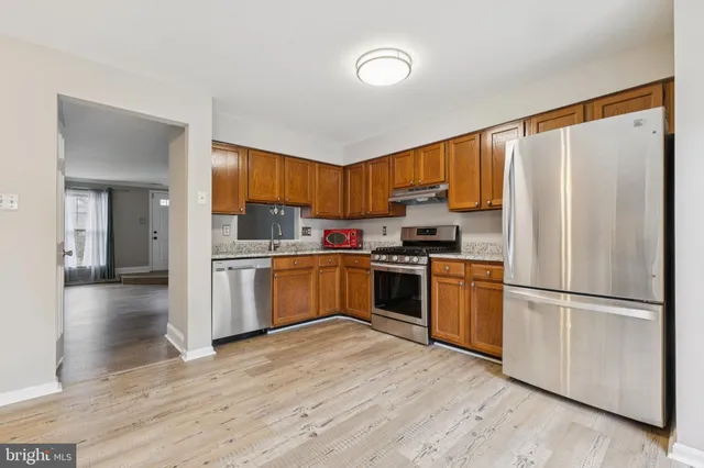 a kitchen with granite countertop appliances a sink and a refrigerator