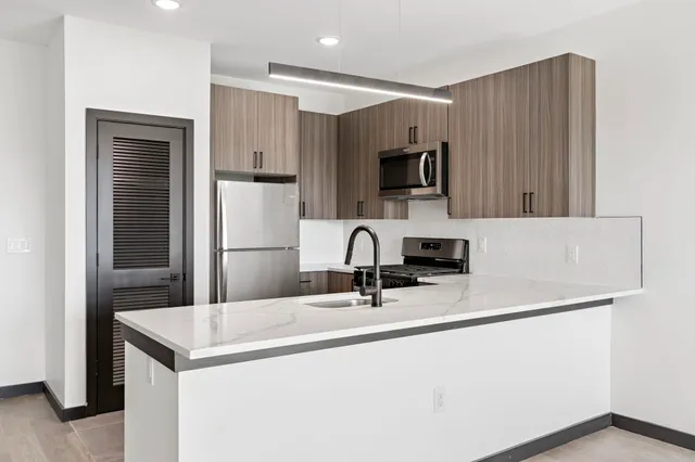 a kitchen with kitchen island a sink a stove and refrigerator