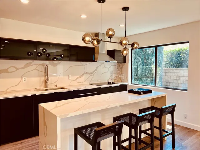 a kitchen with stainless steel appliances a dining table chairs and a refrigerator
