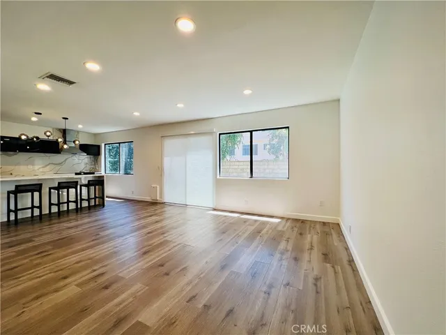 a view of a big room with wooden floor and a hallway