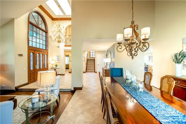 a dining room with wooden floor windows and a chandelier