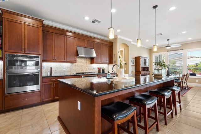 a kitchen with stainless steel appliances kitchen island granite countertop a sink and cabinets