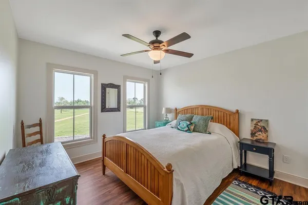a bedroom with a bed and a table in it with wooden floor