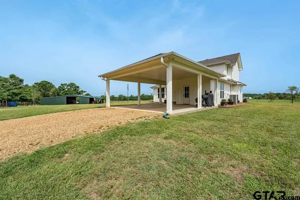 a backyard of a house with table and chairs