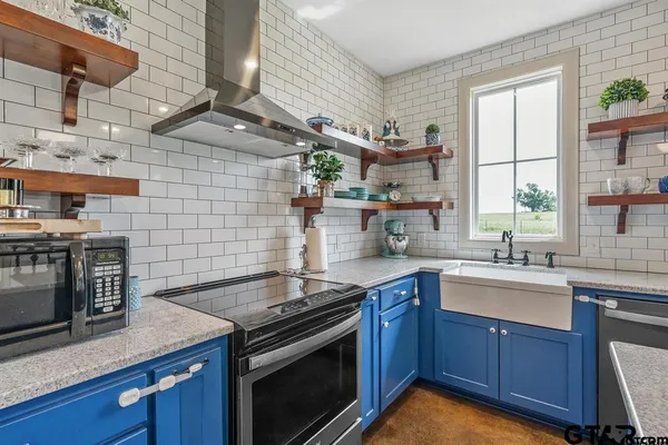 a kitchen with stainless steel appliances granite countertop wooden cabinets stove top oven and sink
