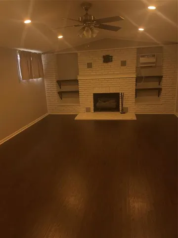 a view of empty room with wooden floor and fireplace
