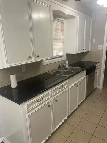 a kitchen with granite countertop white cabinets and sink