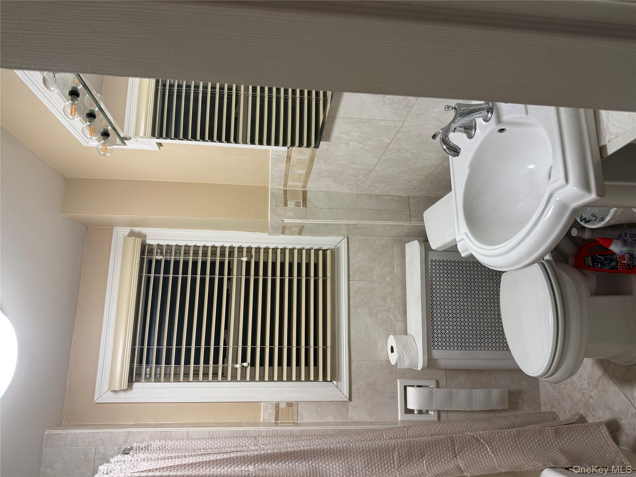 85 Bucknell Road Valley Stream, NY 11580 - Photo 9 of 15 a bathroom with a sink a toilet and a mirror