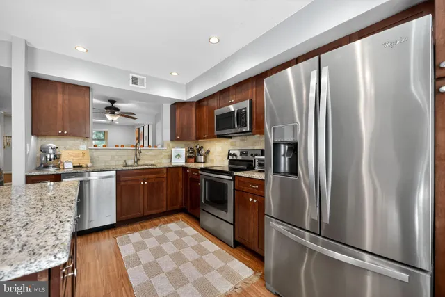 a kitchen with stainless steel appliances granite countertop a refrigerator stove and sink
