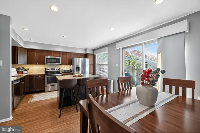 a dining room with furniture potted plants and wooden floor