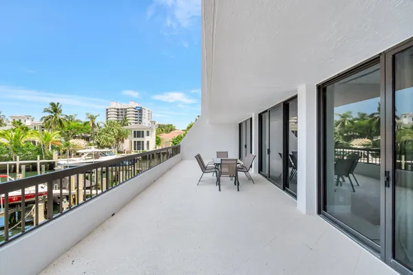 a view of a swimming pool with a table and chairs under an umbrella