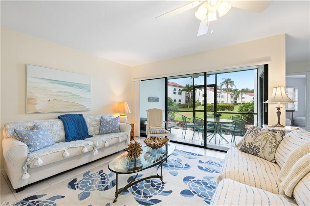 a living room with furniture and a large window with balcony view