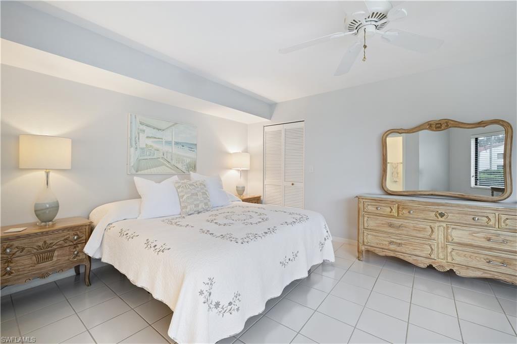 565 Beachwalk Circle, Unit T102 Naples, FL 34108 - Photo 12 of 33 a bedroom with a bed and a dresser