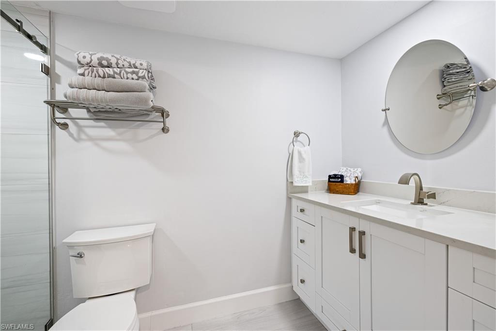 565 Beachwalk Circle, Unit T102 Naples, FL 34108 - Photo 17 of 33 a bathroom with a toilet sink and mirror