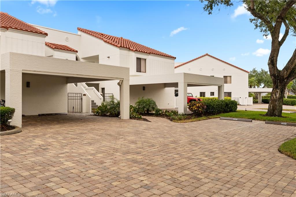 565 Beachwalk Circle, Unit T102 Naples, FL 34108 - Photo 19 of 33 a front view of a house with a yard and garage