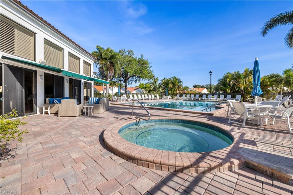 565 Beachwalk Circle, Unit T102 Naples, FL 34108 - Photo 22 of 33 a swimming pool with outdoor seating and yard