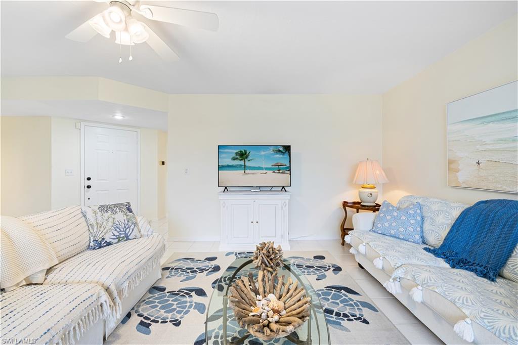 565 Beachwalk Circle, Unit T102 Naples, FL 34108 - Photo 3 of 33 a living room with furniture and a lamp