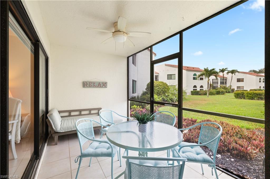 565 Beachwalk Circle, Unit T102 Naples, FL 34108 - Photo 5 of 33 a dining room with furniture a chandelier and wooden floor