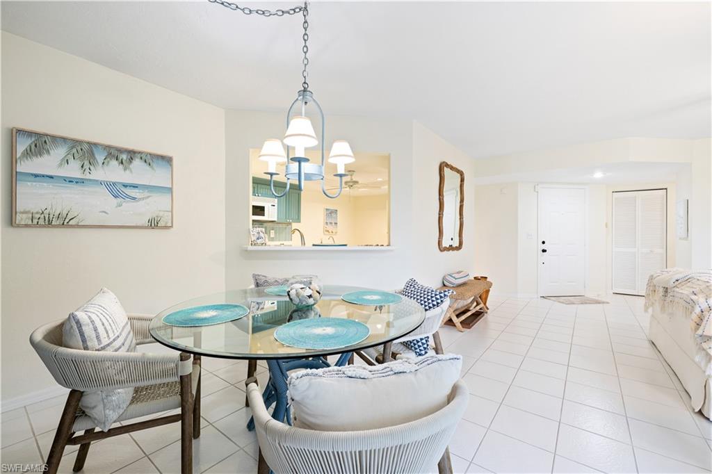 565 Beachwalk Circle, Unit T102 Naples, FL 34108 - Photo 8 of 33 a dining room with furniture and a chandelier