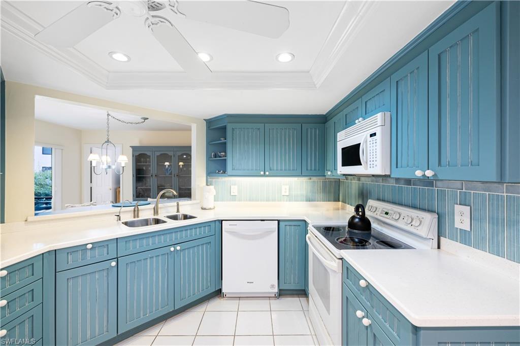 565 Beachwalk Circle, Unit T102 Naples, FL 34108 - Photo 9 of 33 a kitchen with a sink stove and cabinets