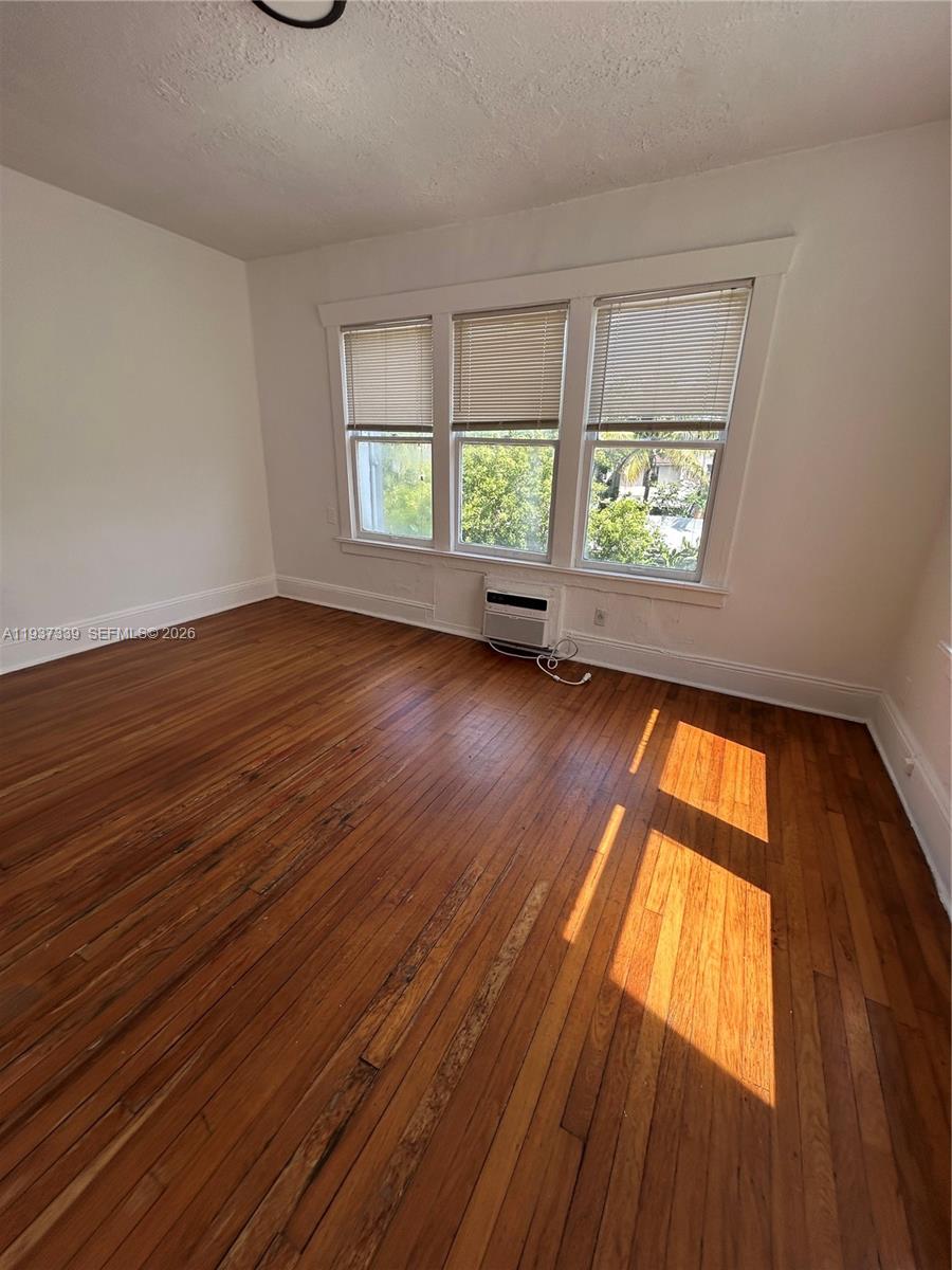 529 Northeast 66th Street, Unit 8 Miami, FL 33138 - Photo 3 of 5 wooden floor in an empty room with a window
