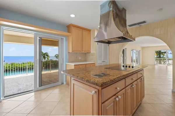 a kitchen with a sink a stove and a view of living room