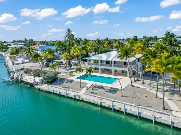an aerial view of a house with a big yard and large trees