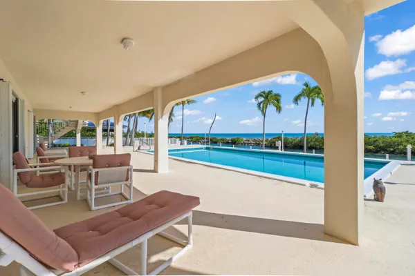 a view of a patio with swimming pool table and chairs