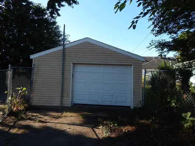 a kitchen with granite countertop a refrigerator a sink and wooden cabinets