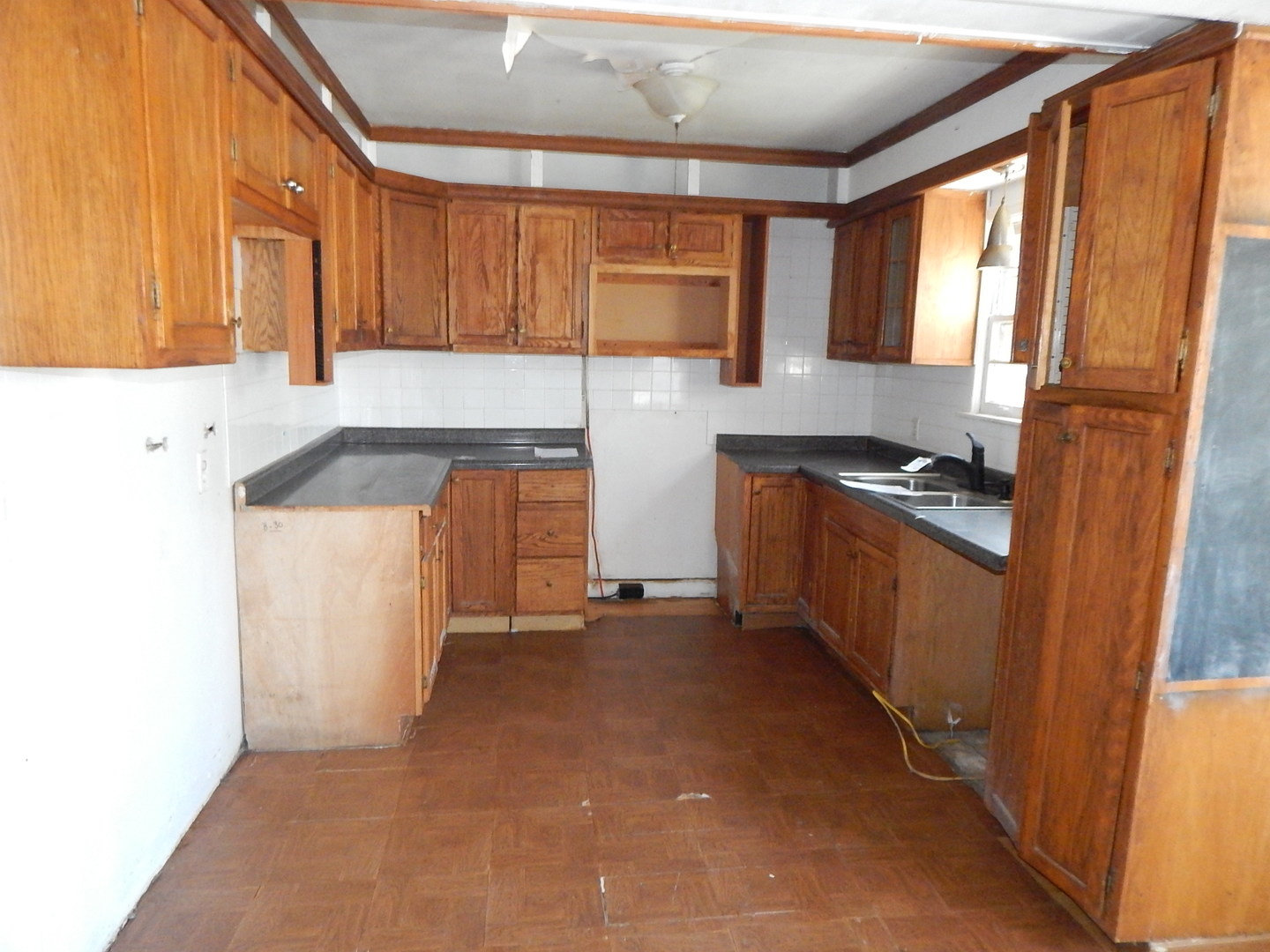 810 West 15th Street Sterling, IL 61081 - Photo 15 of 22 a kitchen with granite countertop a refrigerator a sink and wooden cabinets