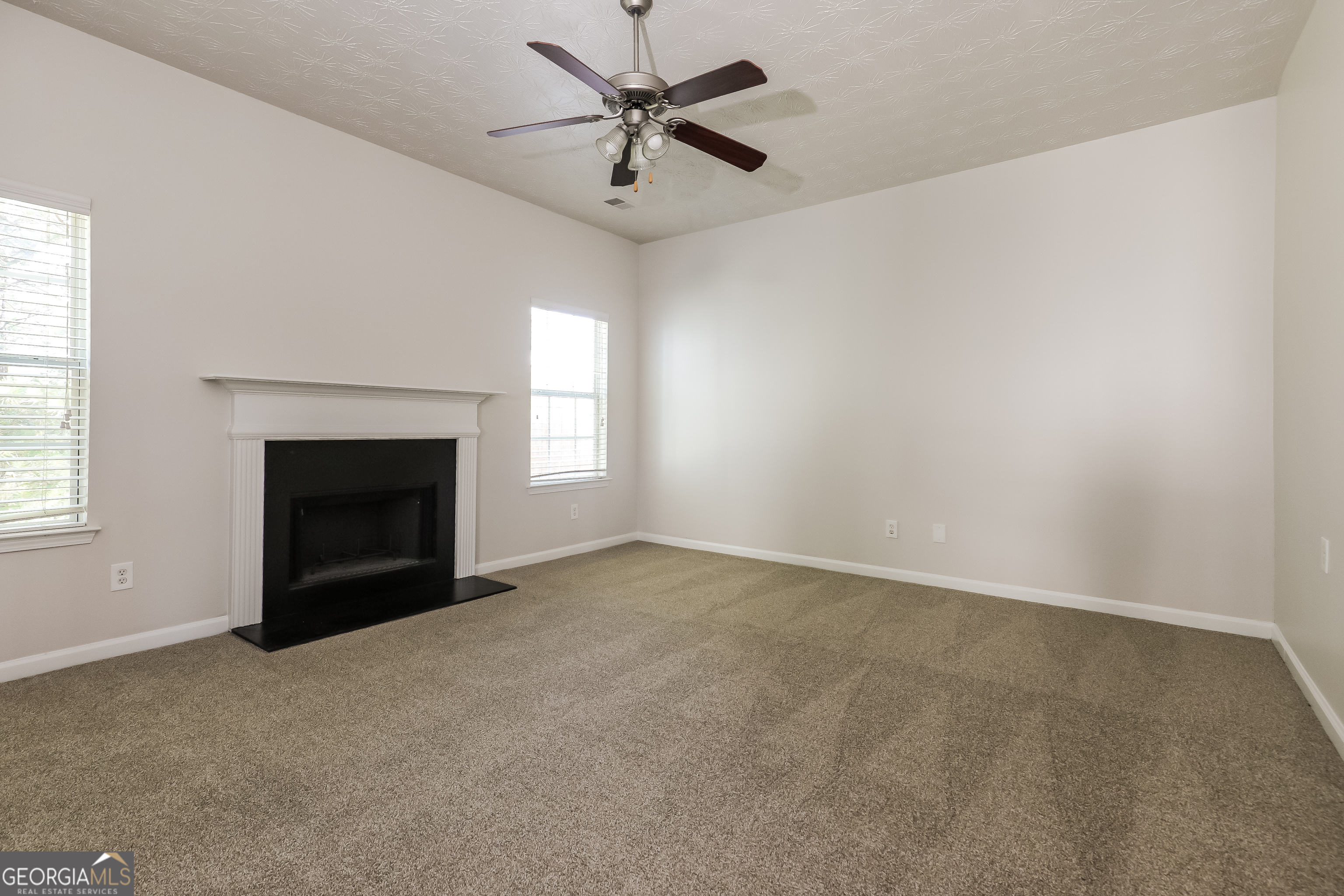 7812 Bell Tower Lane Fairburn, GA 30213 - Photo 2 of 17 an empty room with windows and fireplace