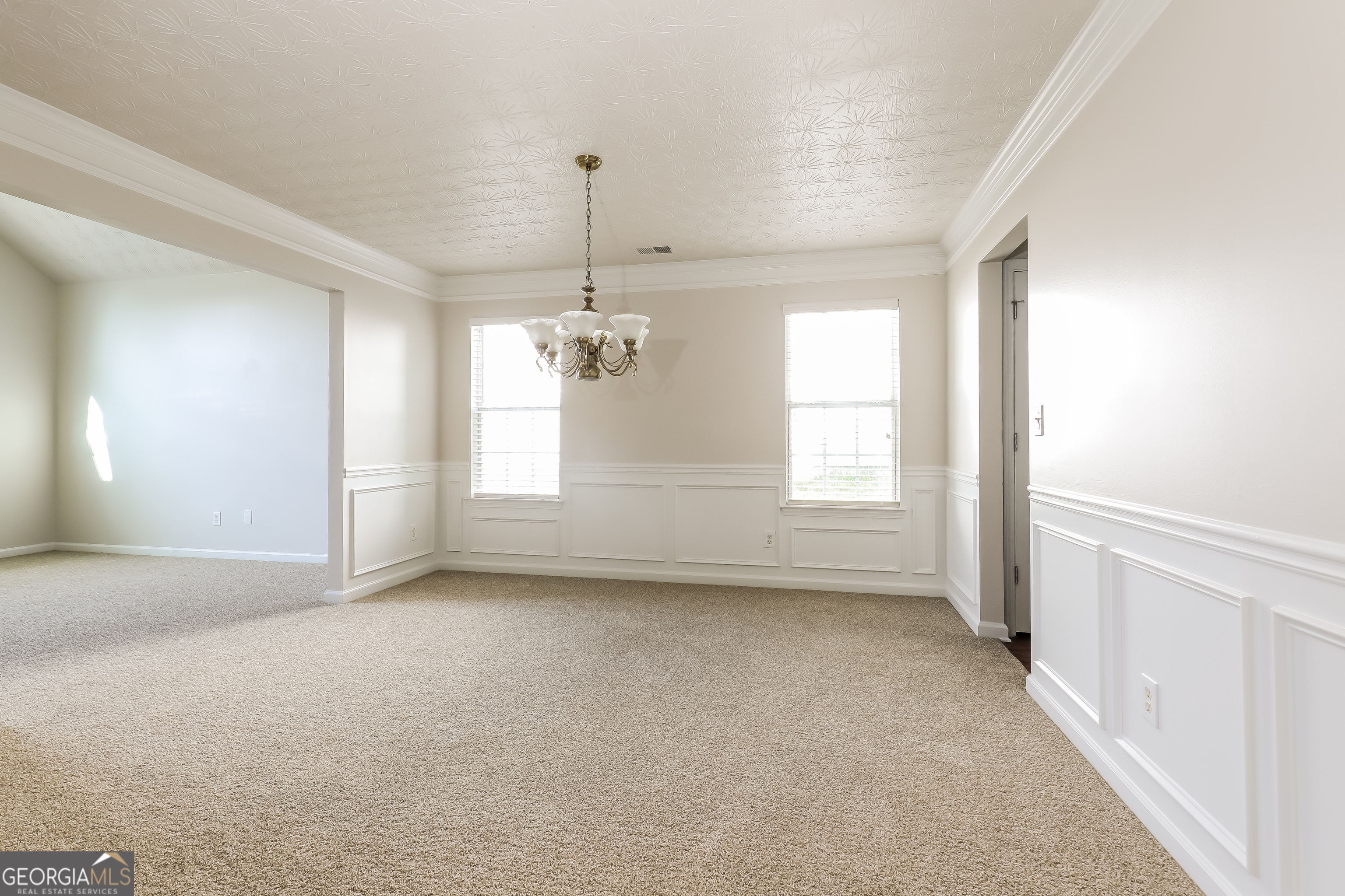 7812 Bell Tower Lane Fairburn, GA 30213 - Photo 4 of 17 en empty room with windows and chandelier