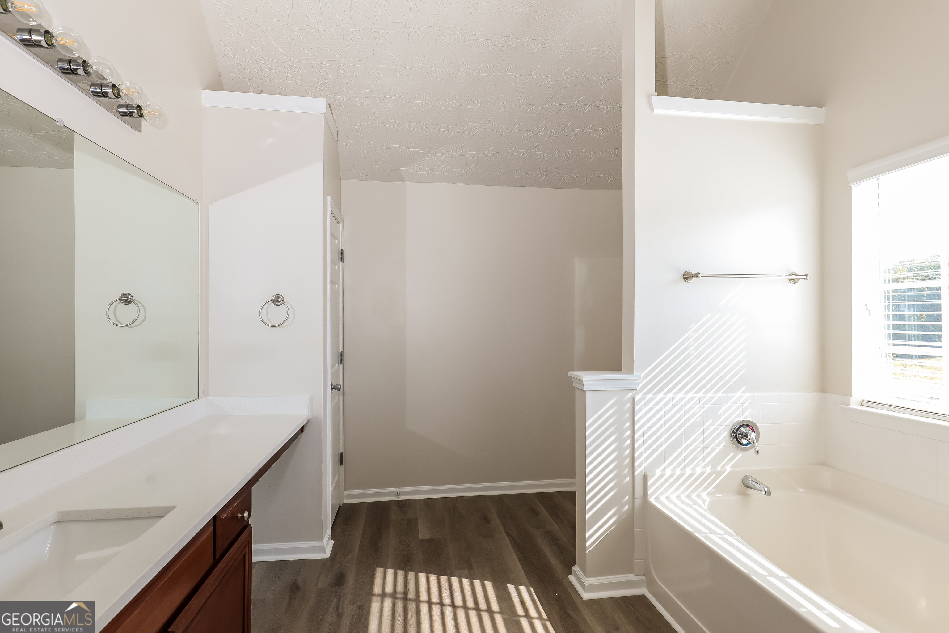 7812 Bell Tower Lane Fairburn, GA 30213 - Photo 10 of 17 a bathroom with a bathtub a sink a vanity and a shower