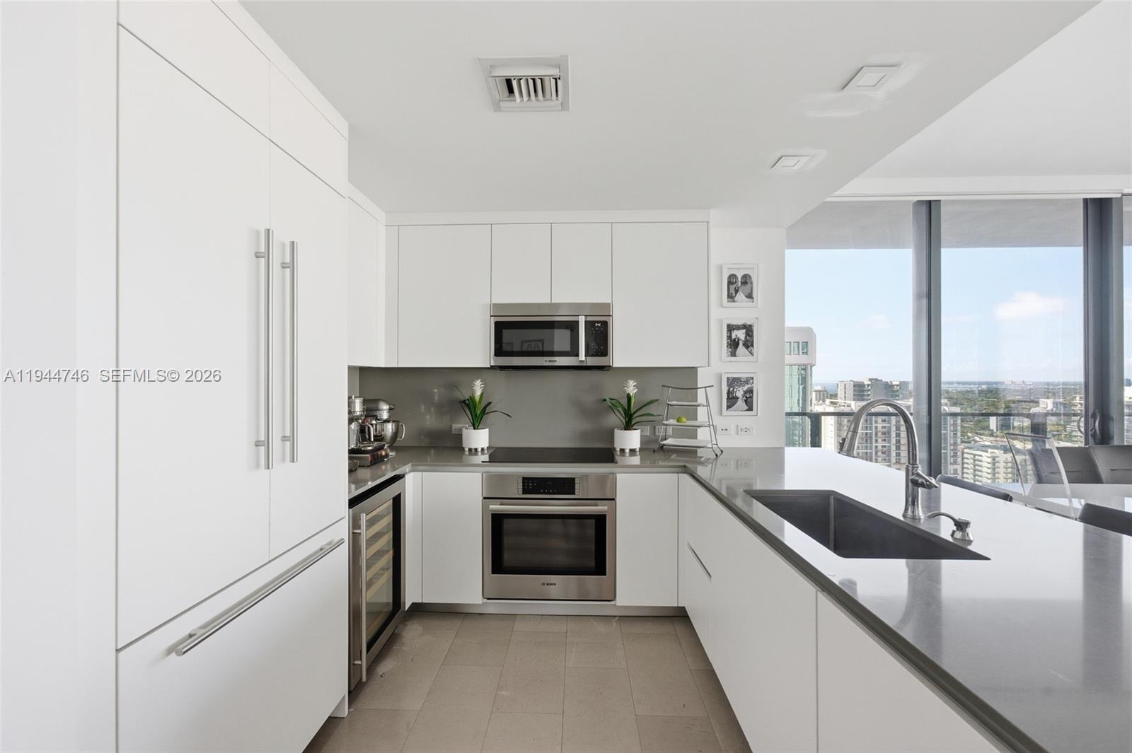 88 Southwest 7th Street, Unit 2302 Miami, FL 33130 - Photo 12 of 43 a kitchen with a sink a counter top space stainless steel appliances and cabinets