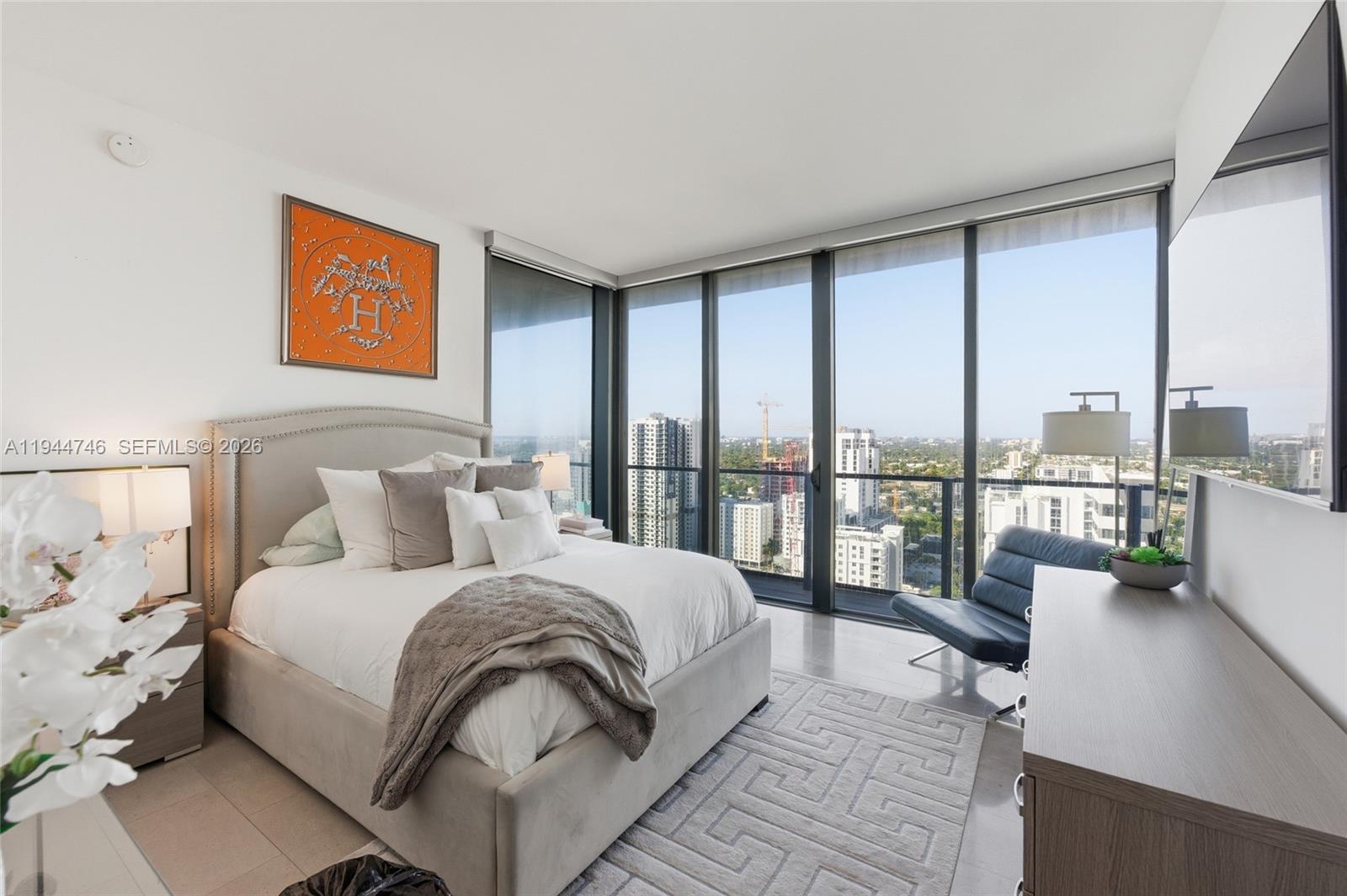 88 Southwest 7th Street, Unit 2302 Miami, FL 33130 - Photo 32 of 43 a large bedroom with a bed and glass window