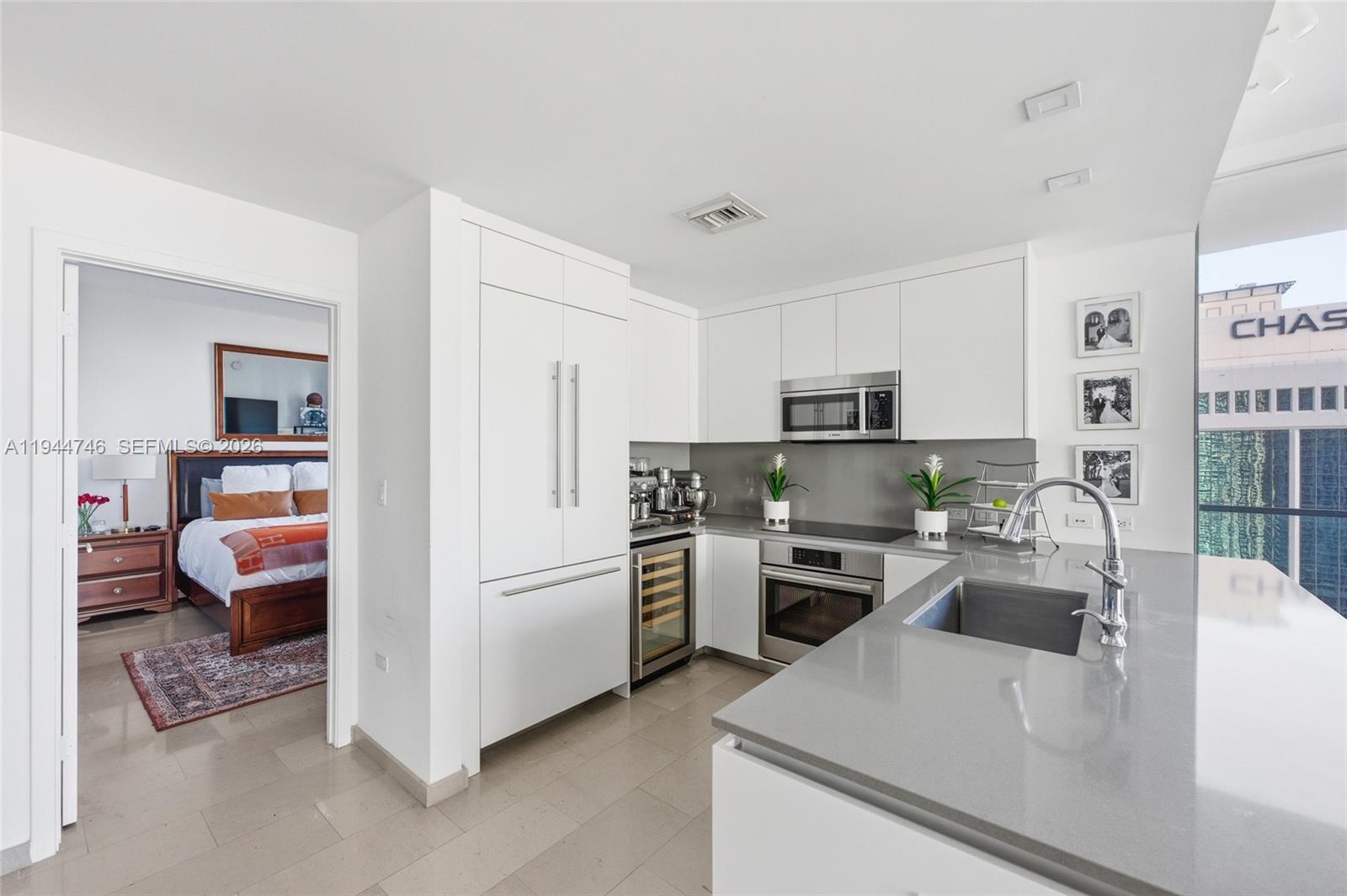 88 Southwest 7th Street, Unit 2302 Miami, FL 33130 - Photo 4 of 43 a kitchen with stainless steel appliances granite countertop a refrigerator sink and stove