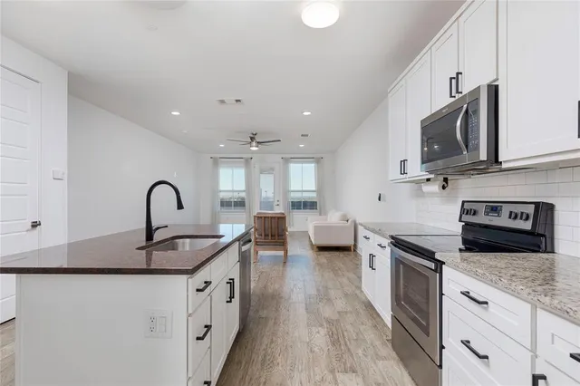 a kitchen with stainless steel appliances granite countertop a sink and cabinets