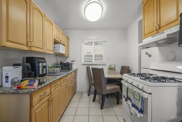 a kitchen with stainless steel appliances granite countertop a stove a sink dishwasher and cabinets with wooden floor