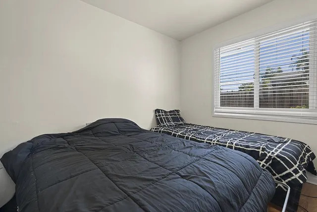 a bed sitting in a bedroom next to a window