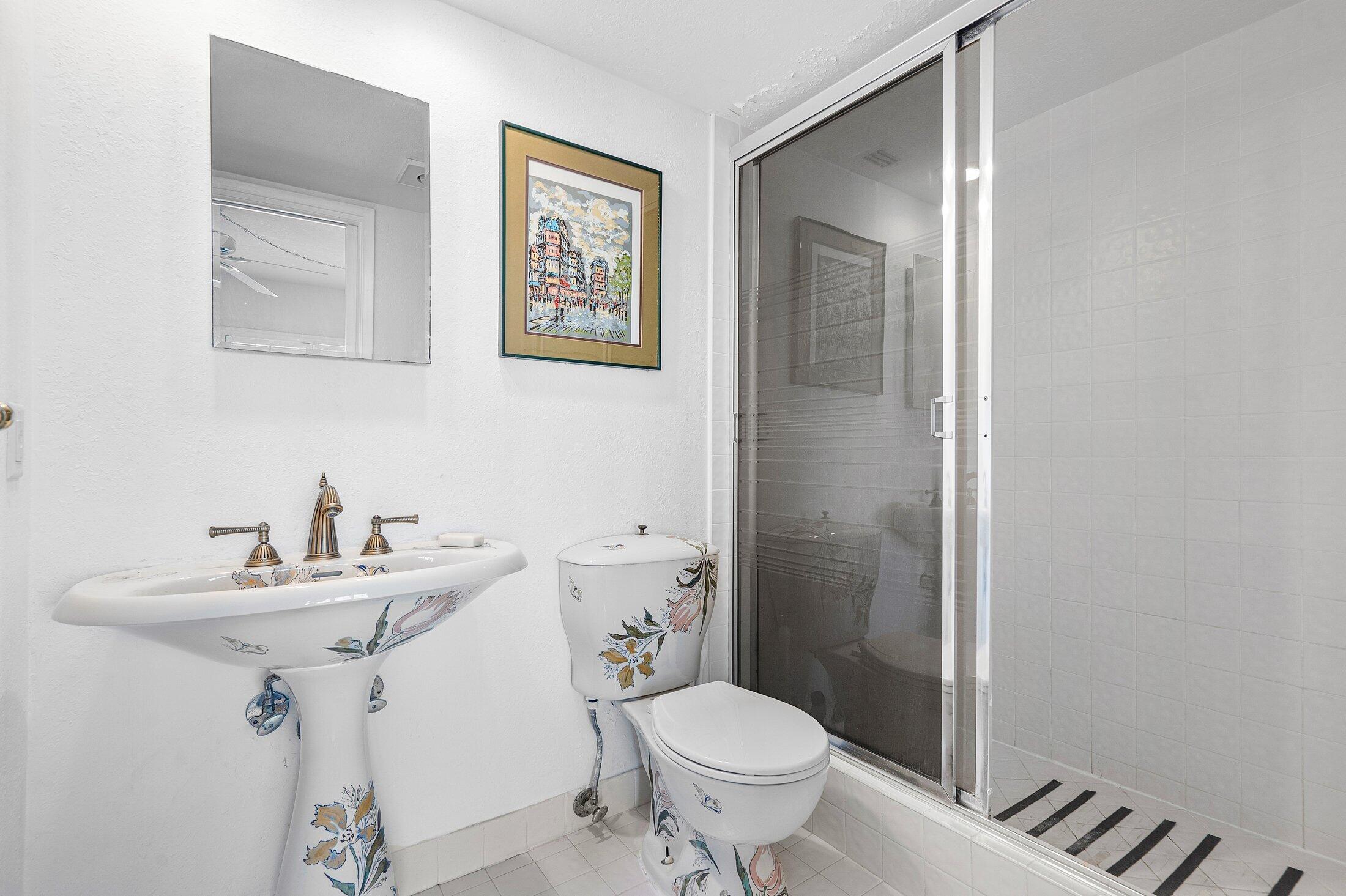 3050 Northeast 48th Court, Unit 402 Lighthouse Point, FL 33064 - Photo 29 of 49 a bathroom with a sink toilet and a mirror
