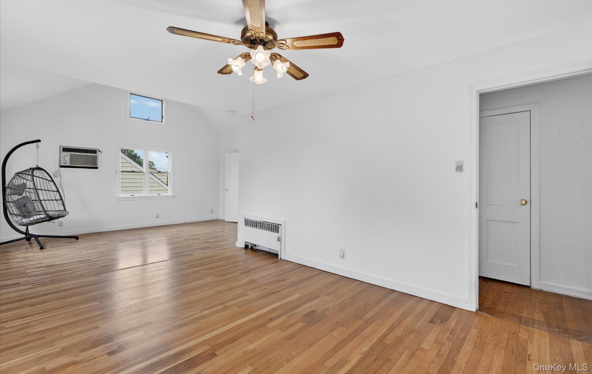 24 Purdue Road Glen Cove, NY 11542 - Photo 24 of 41 an empty room with wooden floor chandelier fan and windows