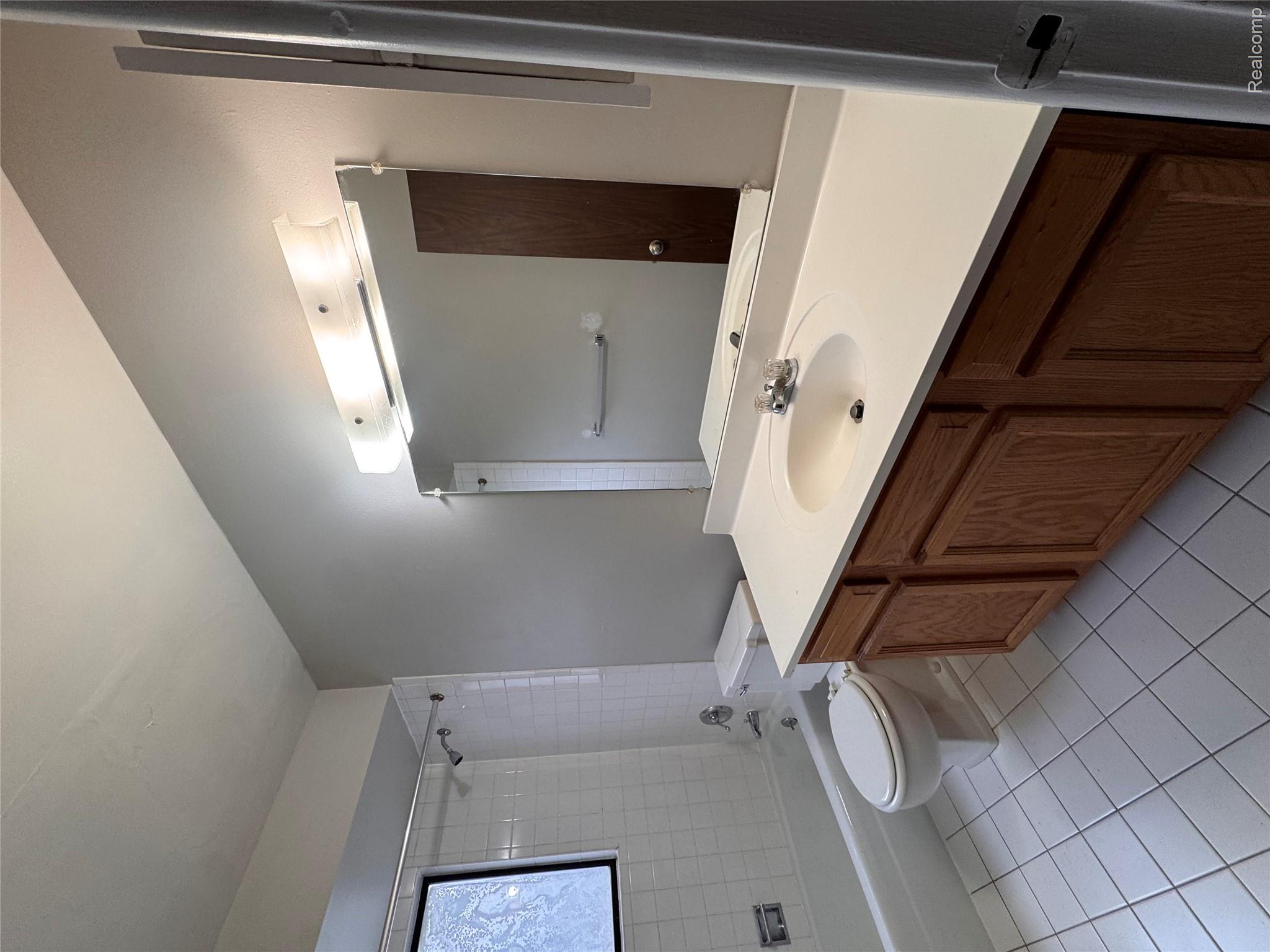32684 Mound Road, Unit 1 Warren, MI 48092 - Photo 8 of 9 Bathroom with vanity, tub / shower combination, and light tile patterned floors