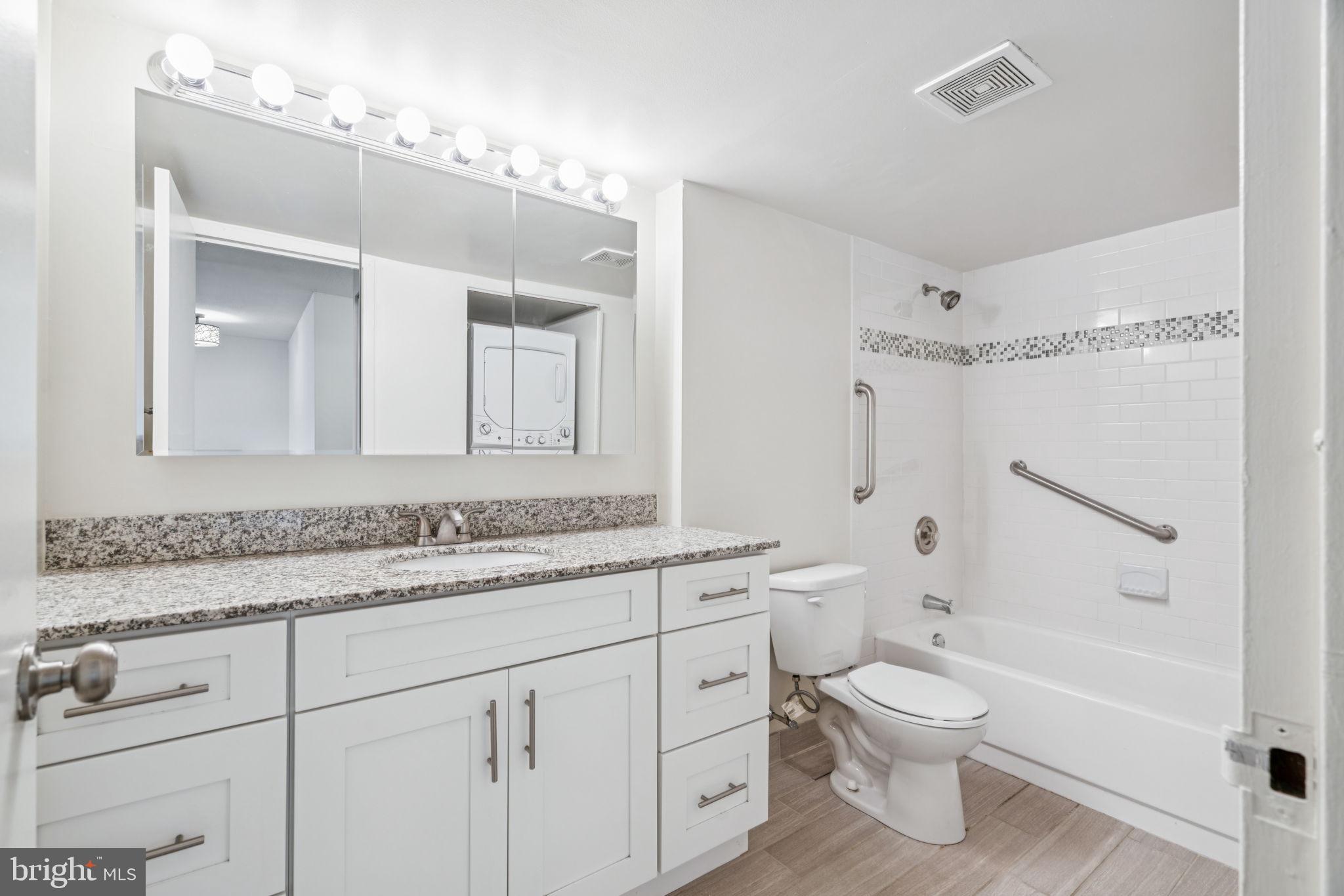 1420 Locust Street, Unit 28P Philadelphia, PA 19102 - Photo 12 of 25 a bathroom with a granite countertop sink a toilet and a bathtub
