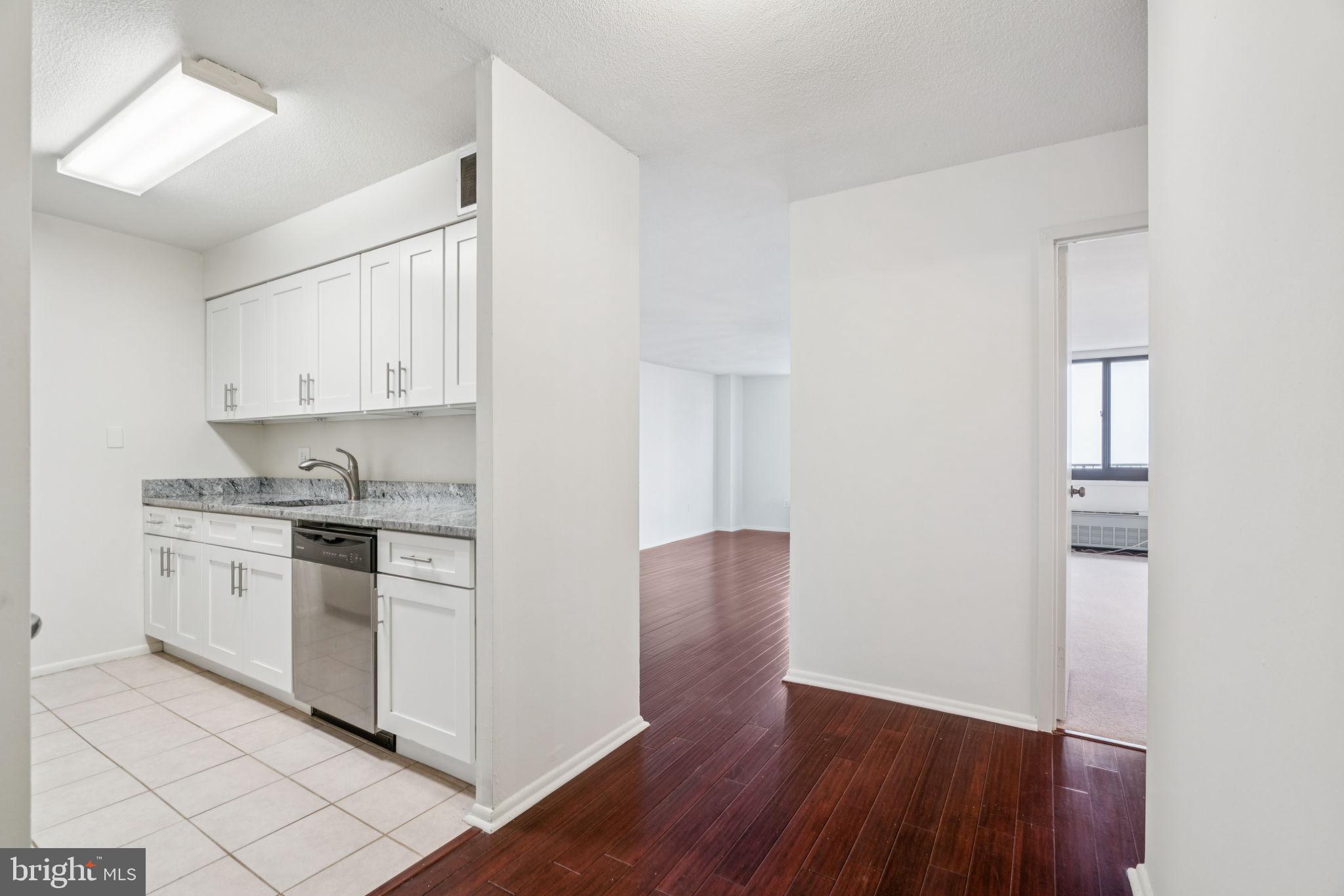 1420 Locust Street, Unit 28P Philadelphia, PA 19102 - Photo 2 of 25 a kitchen with granite countertop white cabinets and white appliances